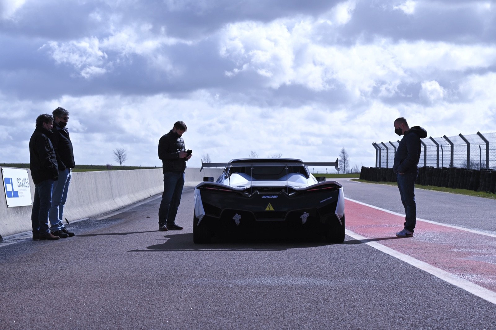 L'eCup 200 à l'arrêt sur un circuit, vue de l'arrière, entourée de l'équipe